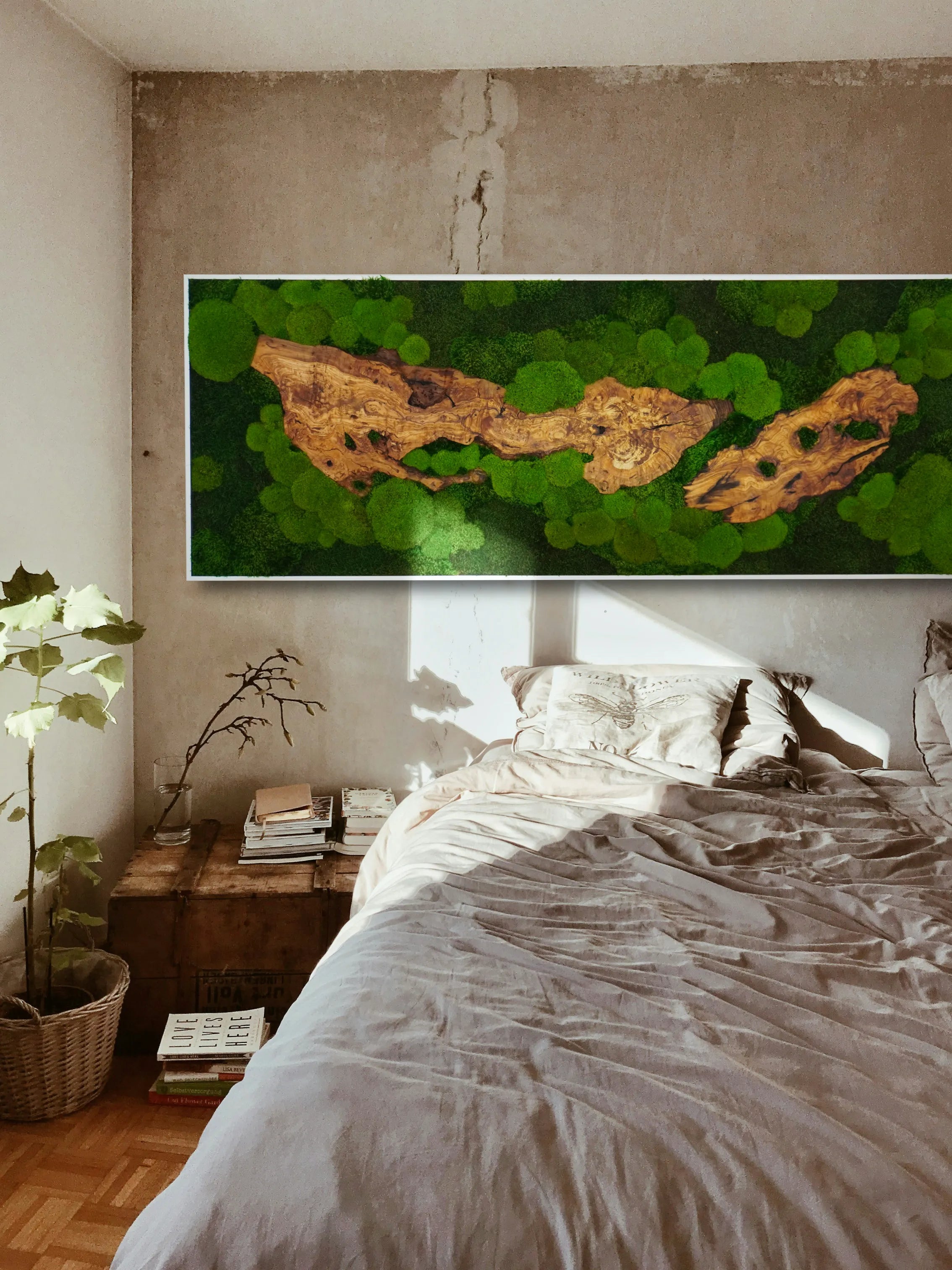 Handgemachte Moosbild-Sonderanfertigung mit edlem Olivenholz in einem silberfarbenen Rahmen - eine kunstvolle Wanddekoration in einem stilvollen Schlafzimmer.