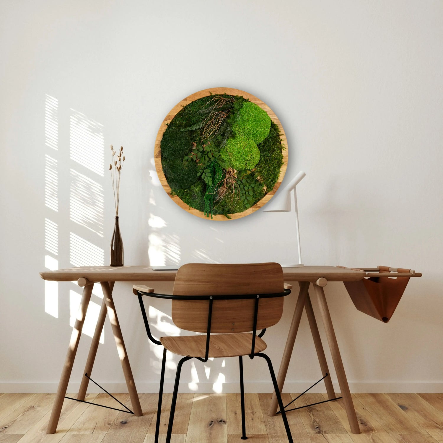 Handgemachtes Moosbild „Circle“ in einem runden Holzrahmen - stilvolle Wanddekoration aus stabilisierten grünen Moosen und Pflanzen über einem Schreibtisch.