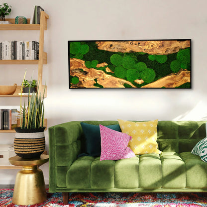 Handgemachtes Moosbild mit dem Namen „Olive“ in einem schwarzen Rahmen - eine kunstvolle Wanddekoration aus grünen Moosen und edlem Holz in einem modernen Wohnzimmer.